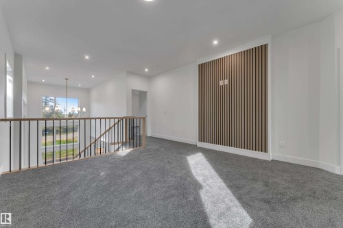 Open-concept upper level with recessed lighting, light-toned wood slat accent wall, and gray carpeting - 247 Linden Loop, Leduc, AB 