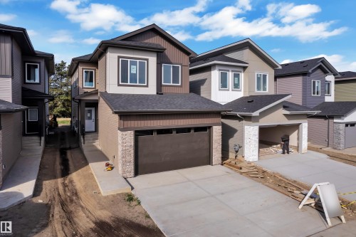 Contemporary exterior with multi-toned siding, stone accents, and a dark asphalt shingle roof - 247 Linden Loop, Leduc, AB 