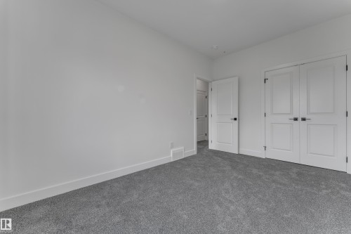 Plush grey carpeting, white interior walls, white trim, and white paneled doors with dark hardware - 247 Linden Loop, Leduc, AB 