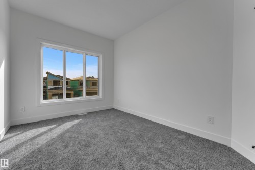 Plush grey carpeting, white painted walls, and a large multi-pane window - 247 Linden Loop, Leduc, AB 