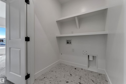 Utility space with built-in shelving, durable flooring, and laundry hookups - 247 Linden Loop, Leduc, AB 