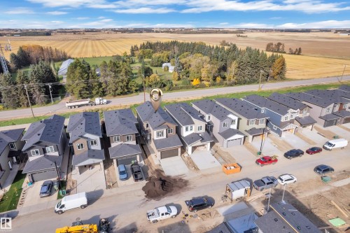 New construction residential properties featuring attached garages and dark shingle roofing - 247 Linden Loop, Leduc, AB 