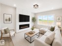Accent wall with integrated linear electric fireplace, recessed lighting, large picture windows, wood-finish flooring, and a modern flush-mount ceiling fixture - 3718 67 Street, Beaumont, AB 