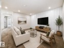 Recessed lighting, white plank accent wall, built-in media console, light neutral carpeting, and white painted walls - 3718 67 Street, Beaumont, AB 