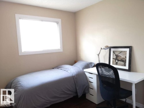 Hardwood-style flooring, neutral wall tones, and a single window with white trim - 144 Kaskitayo Court Nw, Edmonton, AB 