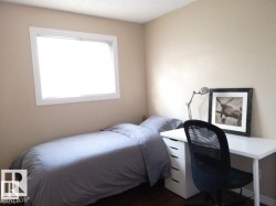 Hardwood-style flooring, neutral wall tones, and a single window with white trim - 