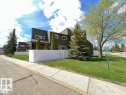 Multi-level exterior with dark green siding, white trim, and a white picket fence - 144 Kaskitayo Court Nw, Edmonton, AB 