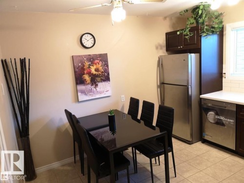 Kitchen featuring stainless steel appliances, white subway tile backsplash, white countertops, and dark wood-finish cabinetry - 144 Kaskitayo Court Nw, Edmonton, AB 