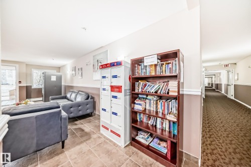 Tiled flooring, built-in shelving, two-tone wall treatment, and a long hallway with carpeted flooring - #302 4309 33 St, Stony Plain, AB 