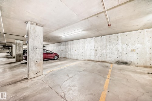 Dedicated parking space featuring a concrete floor and ceiling, and overhead fluorescent lighting - #302 4309 33 St, Stony Plain, AB 