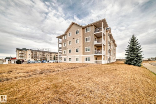 Multi-story building featuring balconies with white railings and an exterior of light-colored siding - #302 4309 33 St, Stony Plain, AB 