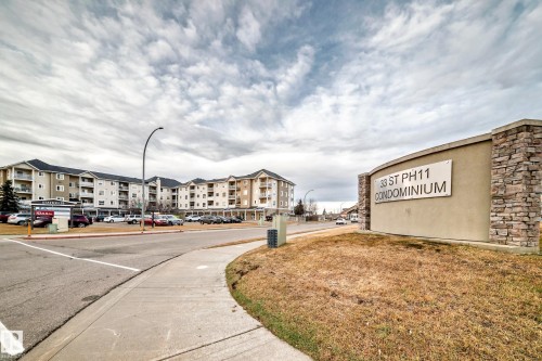 Condominium complex with a stone-clad entry sign, multiple stories, and individual balconies - #302 4309 33 St, Stony Plain, AB 