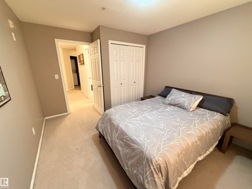Light-colored carpeting, neutral wall palette, and bi-fold closet doors - #302 4309 33 St, Stony Plain, AB 
