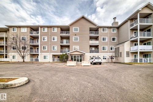 Multi-story exterior with light-toned siding, multiple private balconies, and a central entrance - #302 4309 33 St, Stony Plain, AB 