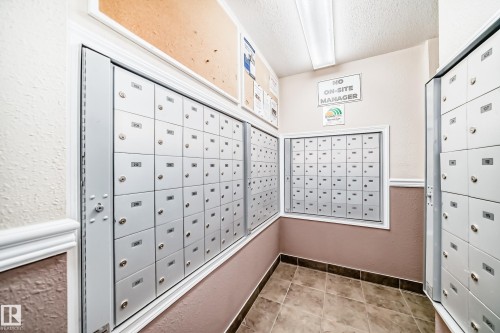 Wall-mounted mailboxes with individual locking compartments, crown molding accents, and tiled flooring - #302 4309 33 St, Stony Plain, AB 