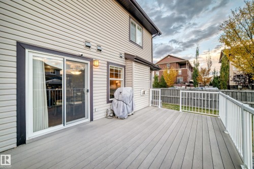 Spacious deck with composite decking, white railing, and sliding glass doors - 1673 Cunningham Way Sw, Edmonton, AB 