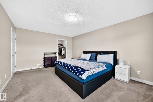 Neutral tone wall paint, textured ceiling, and plush carpeting - 1673 Cunningham Way Sw, Edmonton, AB 