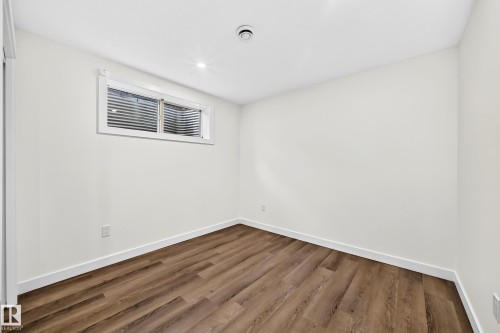 Recessed lighting, wood-finish flooring, white trim, and a window with horizontal blinds - 1673 Cunningham Way Sw, Edmonton, AB 