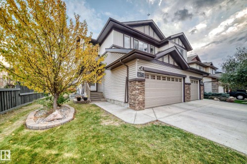 Siding exterior with stacked stone accents, multiple gables, a two-car garage, and a concrete driveway - 1673 Cunningham Way Sw, Edmonton, AB 