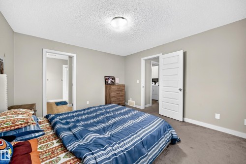Gray wall finishes with white trim, a flush mount ceiling light fixture, and textured ceiling - 1673 Cunningham Way Sw, Edmonton, AB 