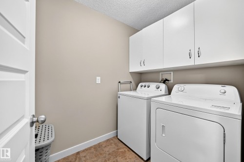 White cabinetry with chrome hardware - 1673 Cunningham Way Sw, Edmonton, AB 