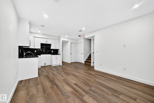Open-concept layout with wood-finish flooring, recessed lighting, and white walls - 1673 Cunningham Way Sw, Edmonton, AB 
