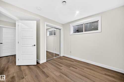 Wood-finish flooring, white paneled doors, mirrored closet doors, and recessed lighting - 1673 Cunningham Way Sw, Edmonton, AB 