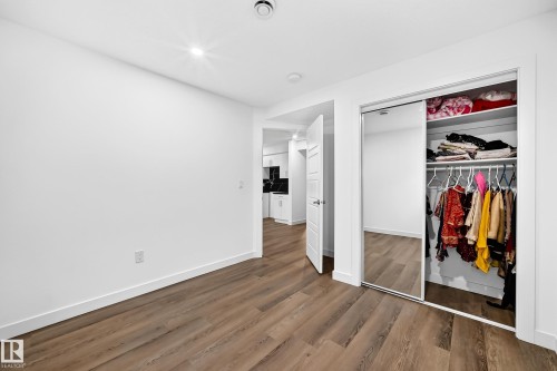 Wood-finish flooring, recessed lighting, white walls, and a mirrored closet door - 1673 Cunningham Way Sw, Edmonton, AB 