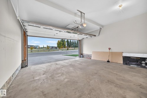 Concrete flooring, white walls, overhead lighting, garage door opener, street visibility - 1673 Cunningham Way Sw, Edmonton, AB 