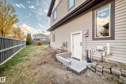 Light-colored horizontal siding with dark trim accents - 1673 Cunningham Way Sw, Edmonton, AB 
