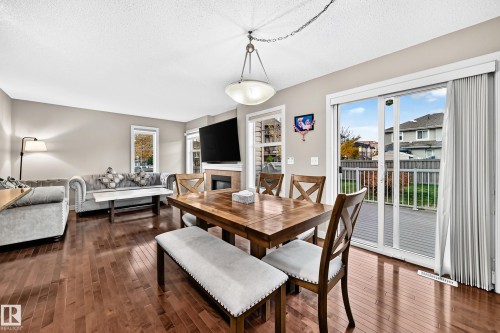 Hardwood flooring, recessed fireplace, sliding glass door, overhead lighting fixture, and a neutral color palette - 1673 Cunningham Way Sw, Edmonton, AB 