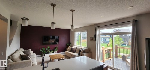 Open-concept living space with pendant lighting and recessed ceiling lights - 3779 Cherry Loop Sw, Edmonton, AB 