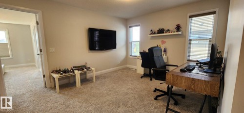 Carpeted room with neutral wall tones and multiple windows - 3779 Cherry Loop Sw, Edmonton, AB 