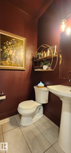 Pedestal sink, wall-mounted light fixture, and floor-set toilet - 3779 Cherry Loop Sw, Edmonton, AB 