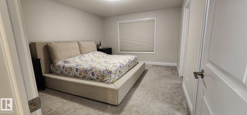 Neutral wall paint, ceiling-mounted lighting, white trim, and a window with a roller shade - 3779 Cherry Loop Sw, Edmonton, AB 