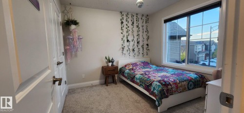 Plush carpeting, a large window, and a built-in closet - 3779 Cherry Loop Sw, Edmonton, AB 