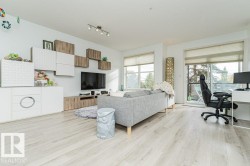 Light wood-finish flooring throughout, track lighting, and a built-in media console with storage - 