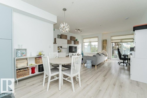 Open-concept living space featuring wood-finish flooring and extensive built-in shelving - #202 9503 101 Av Nw, Edmonton, AB 