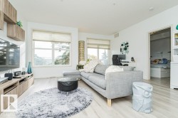 Light wood-finish flooring throughout, bright white walls, and built-in wood-finish media console - 