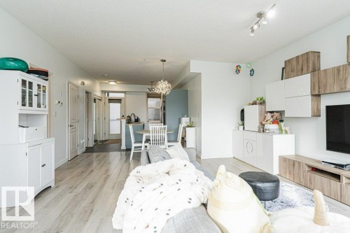 Open-concept living area with light wood-finish flooring, recessed lighting, and track lighting - #202 9503 101 Av Nw, Edmonton, AB 