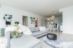 Open concept living space featuring light wood-finish flooring, recessed lighting, and a contemporary dining area pendant light - 