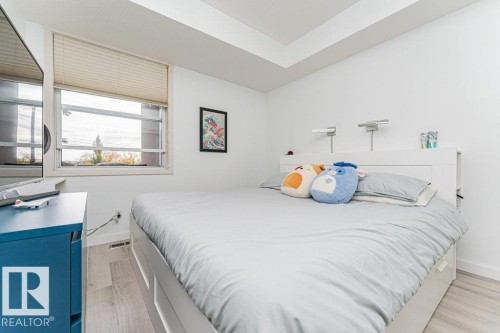 Recessed ceiling, window with blinds, wood-finish flooring, built-in headboard, wall-mounted reading lights - #202 9503 101 Av Nw, Edmonton, AB 