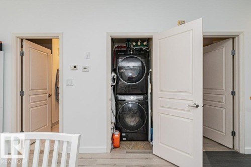 Laundry closet with stacked washer and dryer unit - #202 9503 101 Av Nw, Edmonton, AB 