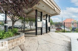 Covered entryway with decorative wrought iron gate and a stone-faced planter - 