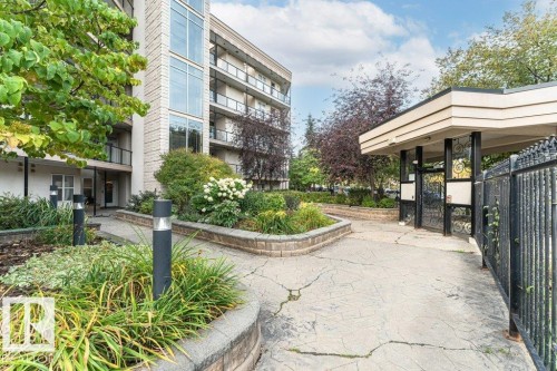 Multi-story building featuring a stone facade and glass balcony railings - #202 9503 101 Av Nw, Edmonton, AB 