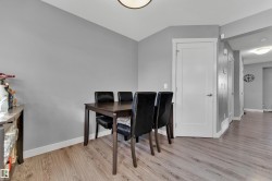 Wood-finish flooring throughout, complemented by light grey walls and white trim - 