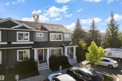 Two-story attached dwelling with dark siding and light trim - 