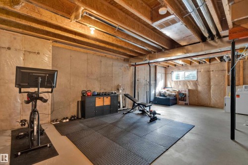 Concrete foundation walls with exposed wood joist ceiling and utility infrastructure - #22 4205 30 St Nw, Edmonton, AB 