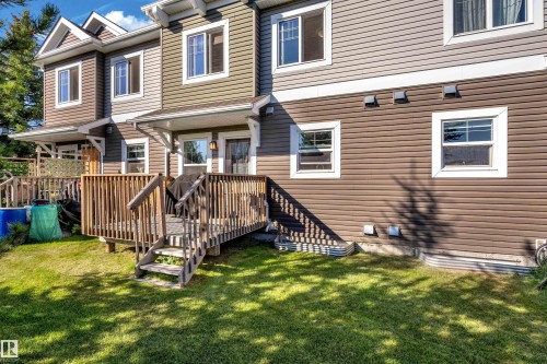 Expansive rear deck with wooden railing and steps, offering direct access to a green lawn - #22 4205 30 St Nw, Edmonton, AB 