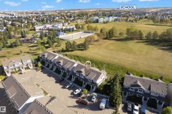 Townhome property with asphalt shingle roofing and an exterior featuring dormer windows - 
